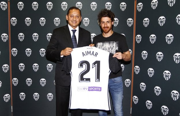 Aimar recibe una camiseta de manos de Anil Murthy.