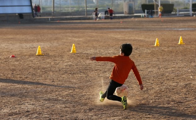 Un niño golpea un balón en un campo de la Comunitat Valenciana.