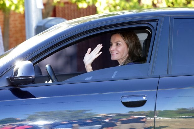 La Reina Letizia saluda a los fotógrafos apostados a la puerta del colegio de sus hijas.
