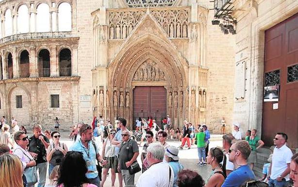 Un grupo de turistas con un guía en la plaza de la Virgen. /MONZÓ