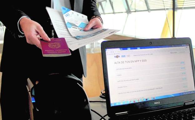 Un pasajero enseña el pasaporte en el aeropuerto de Barajas./R.C.