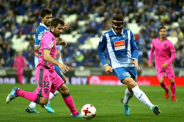 Coke, que debutó ayer con el Levante, disputa el balón con López. / efe