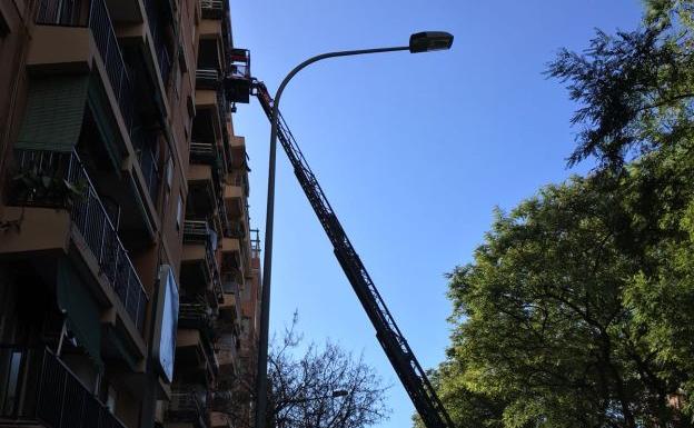 La escalera desplegada por los bomberos en la fachada del edificio./Héctor Sirera