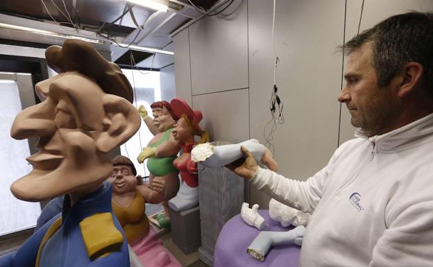 El presidente de la falla sujeta los brazos de un ninot inacabado.