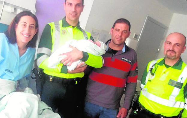 Uno de los guardias sostiene al bebé, junto a sus padres. / g. civil