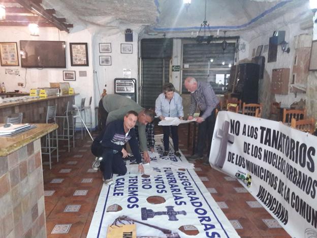 Vecinos preparan algunas de las pancartas que colocarán en la concentración vecinal prevista para el próximo 14 de abril. / lp