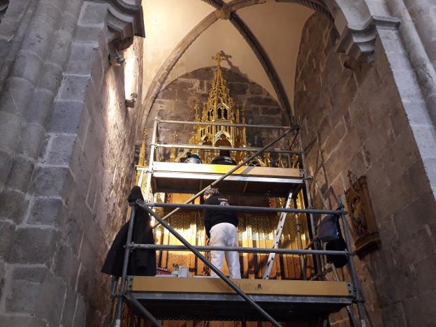 Dos doradoras de la empresa de restauración de patrimonio trabajando ayer en el retablo neogótico de la Colegiata de Gandia. / r. escrihuela
