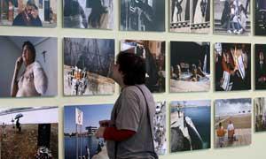 Un hombre observa varias de las fotografías que forman parte de la exposición "Fragments d'un any 2009" que recrea la visión de un año en la Comunitat a través de los objetivos de 38 profesionales. FOTO EFE./