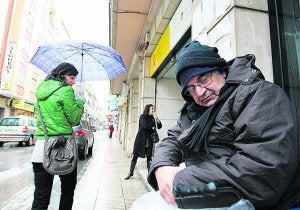 Juan Vilas aguanta el frío de la calle e intenta protegerse de la lluvia sin abandonar su pugna. ::
F. GARCÍA/