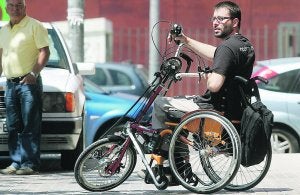 Elies, en su bici junto a su empresa. ::
DAMIÁN TORRES/