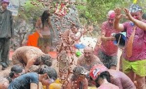 Los participantes llenos de barro disfrutan de la insólita batalla que servirá para reforestar el parque. :: MARIO AYÚS/