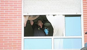 Un agente de la Policía Nacional analiza la vivienda del hombre fallecido en busca de pruebas. :: FRANCISCO GARCÍA/