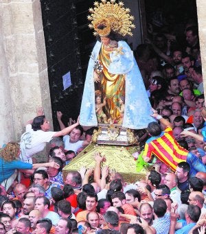 Fieles tocando el manto de la Virgen, tras la salida de la Basílica. :: JUANJO MONZÓ/