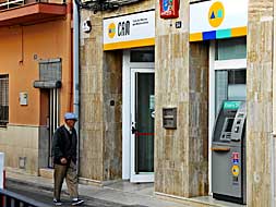 Un transeúnte pasa por delante de la sucursal bancaria atracada./