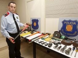 Un agente de los Mossos d'Esquadra muestra una de las mazas intervenidas a los delincuentes kosovares./