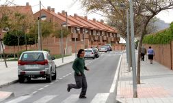 Un joven cruza una de las calles de la zona nueva de la barriada alicantina de Ciudad Jardín./