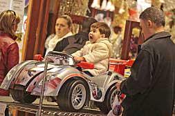 Un niño prueba un coche en una tienda de juguetes de Gandia./