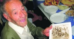 UN 'RIBERER'. Juan Bautista Cabrera muestra una foto de la década de 1930 con los compañeros de los arrozales . /RAÚL MARTÍNEZ/