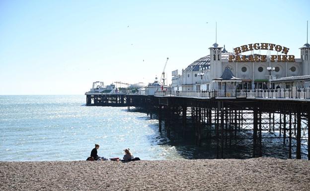 Dos personas sentadas en la playa en Brighton, Reino Unido/EFE