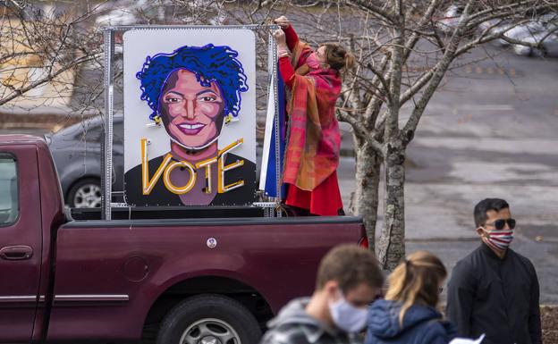 Una mujer latina de Lilburn porta en su vehículo un cartel de Stacey Abrams./Efe