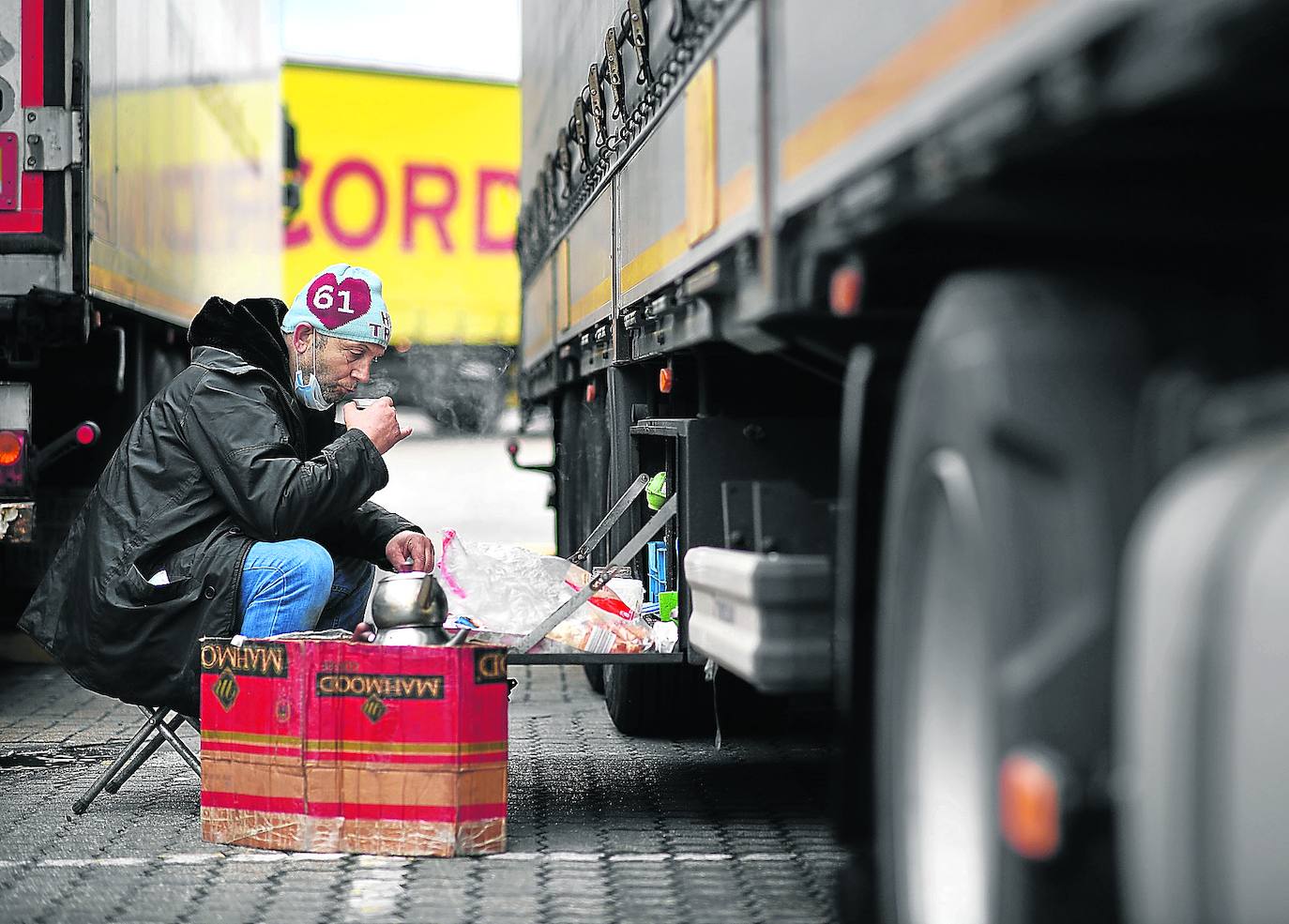 Un camionero turco bebe té junto a su trailer frigorífico estacionado en el puerto de Dover, mientras se resuelve la madeja de permisos necesarios para llevar su carga a destino.