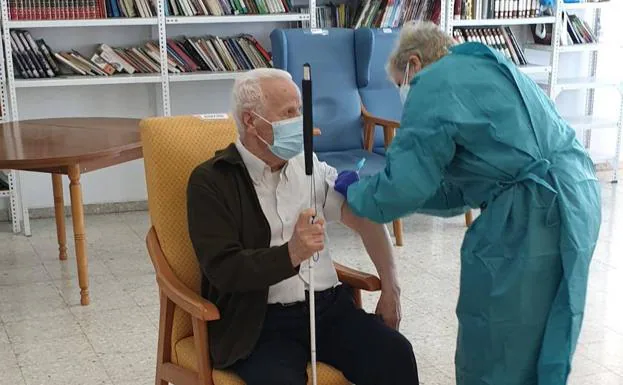 Una enfermera vacuna a un anciano en una residencia./R. C.