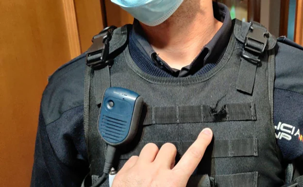 Una mano señala un pinchazo en el chaleco antibalas del policía. /LP