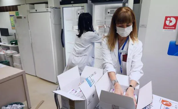 Empleadas del centro médico guardan las vacunas de AstraZeneca en neveras a su llegada al Hospital Clínico Universitario de Zaragoza, este lunes /EFE