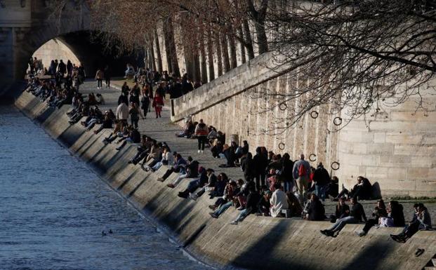 Cientos de personas se asomaban al Sena en París este sábado, primer día en que entraba en vigor el confinamiento./REUTERS