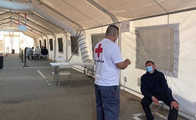Un miembro de Cruz Roja atiende a una de las personas que iba a bordo de la patera interceptada ayer. /E. P.