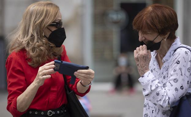 Dos mujeres que utilizan mascarilla conversan en el centro de Madrid./EP