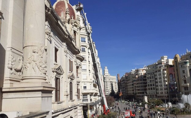 Firefighters check the cornices of the Plaza del Ayuntamiento de Valencia before the mascletaes