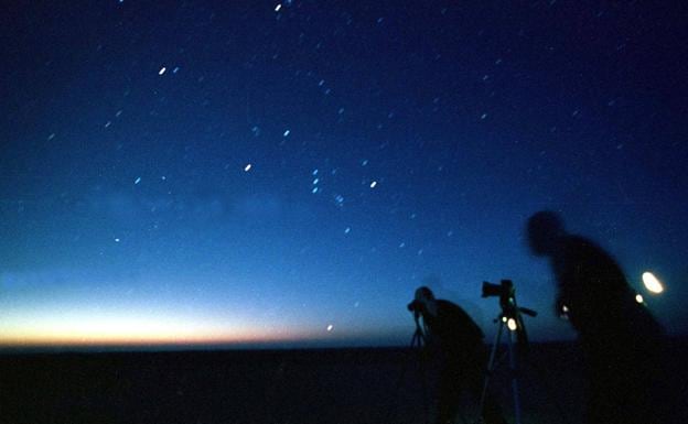 Unos fotógrados contemplan una lluvia de estrellas.