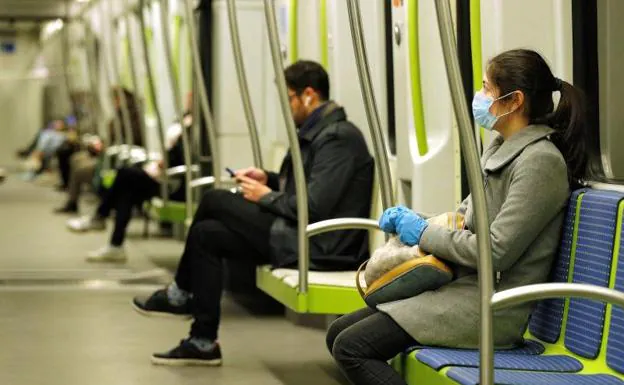 Un usuario del metro con mascarilla. 