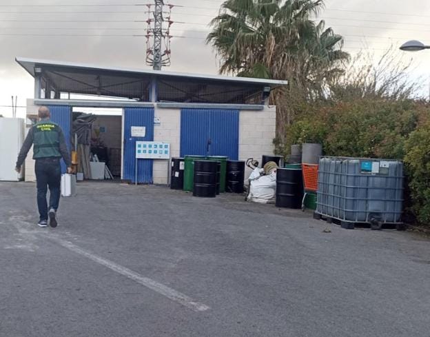 Un Guardia Civil con un maletín en un centro de reciclaje. 